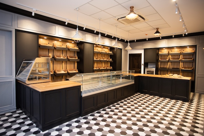 Bakery shop interior with dark counters and wooden bread shelves