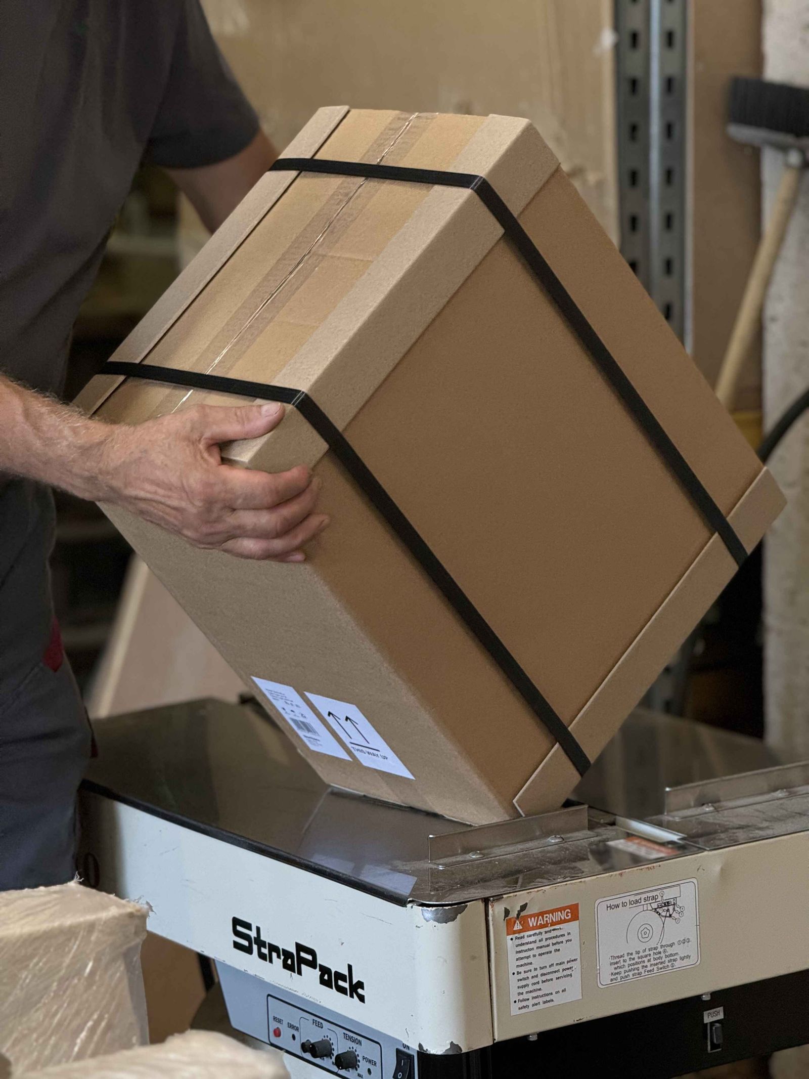 Packing a furniture box on a strapping machine for delivery