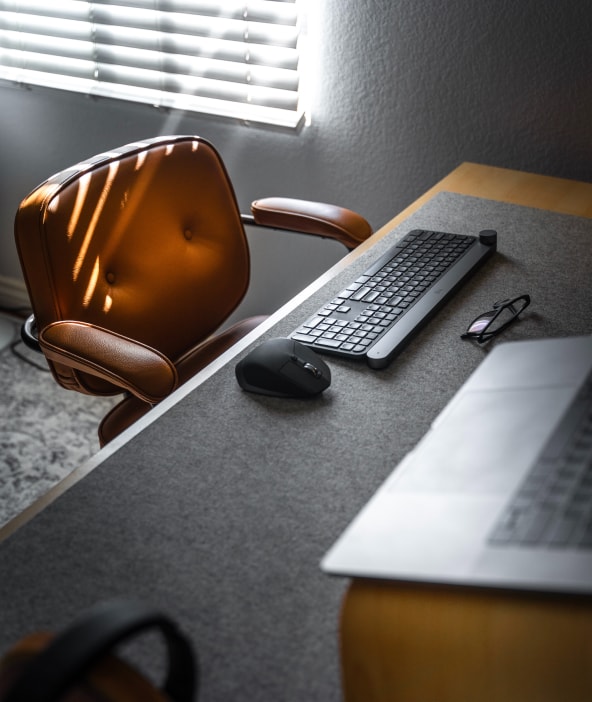 Desk with keyboard, laptop and leather office chair