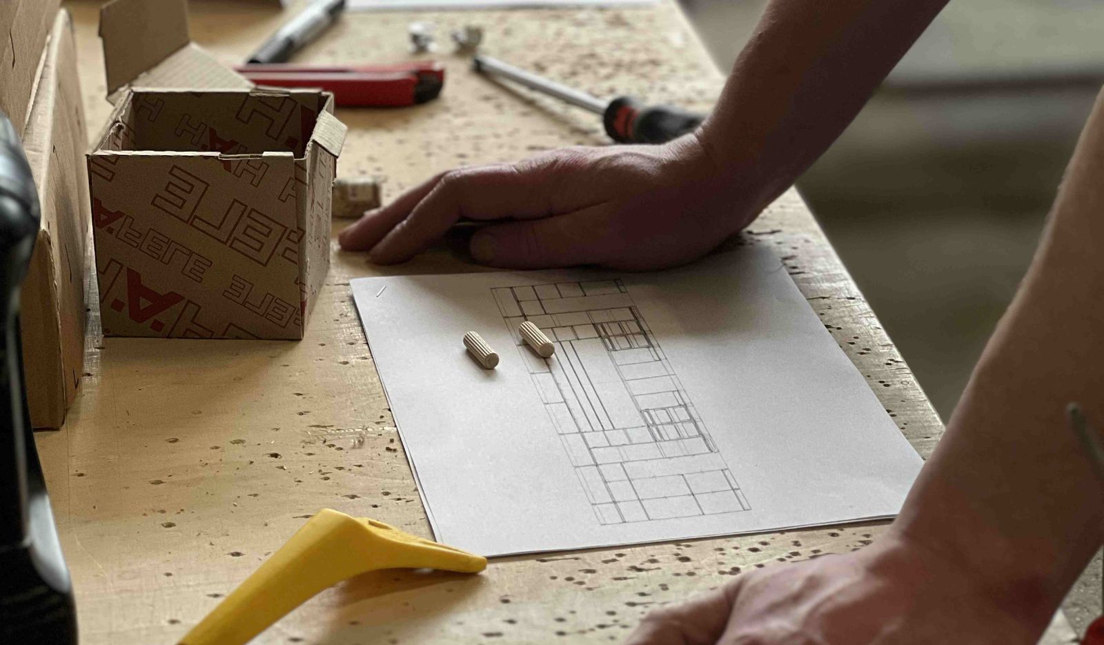 Designer marking up furniture drawings at a workbench