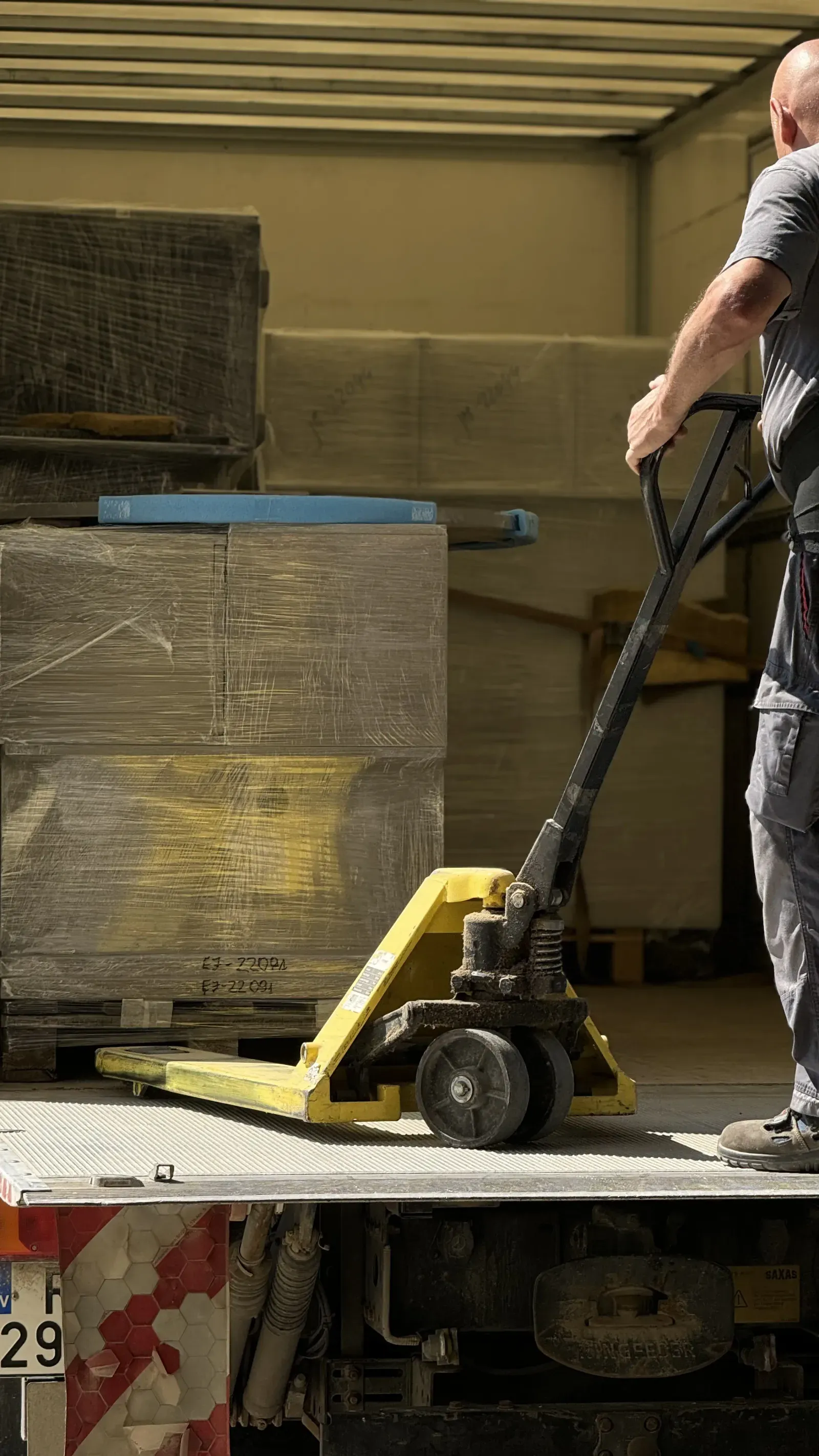 Packed furniture loaded onto a truck with a pallet jack