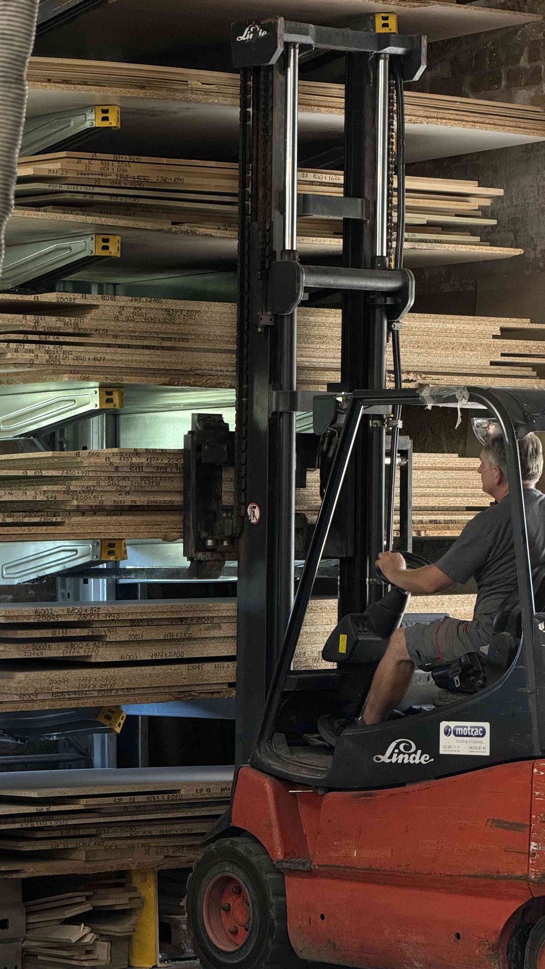 Forklift moving timber sheets in the warehouse