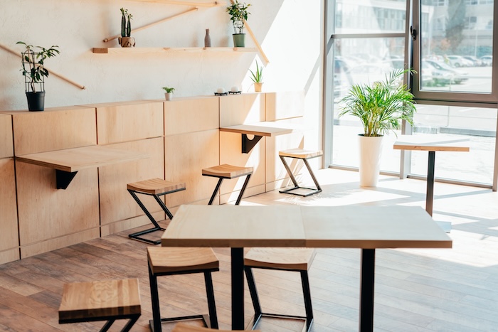 Café interior with wall-mounted tables and wooden stools