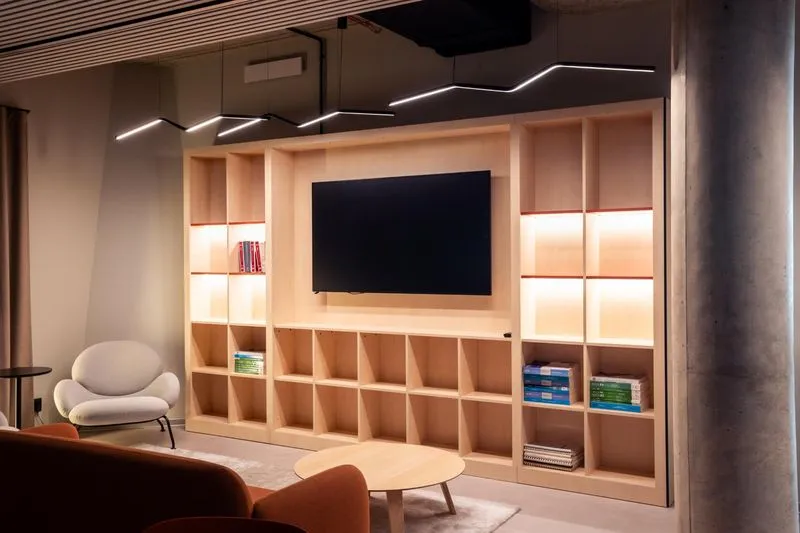 Lounge with an oak media wall and lit shelving