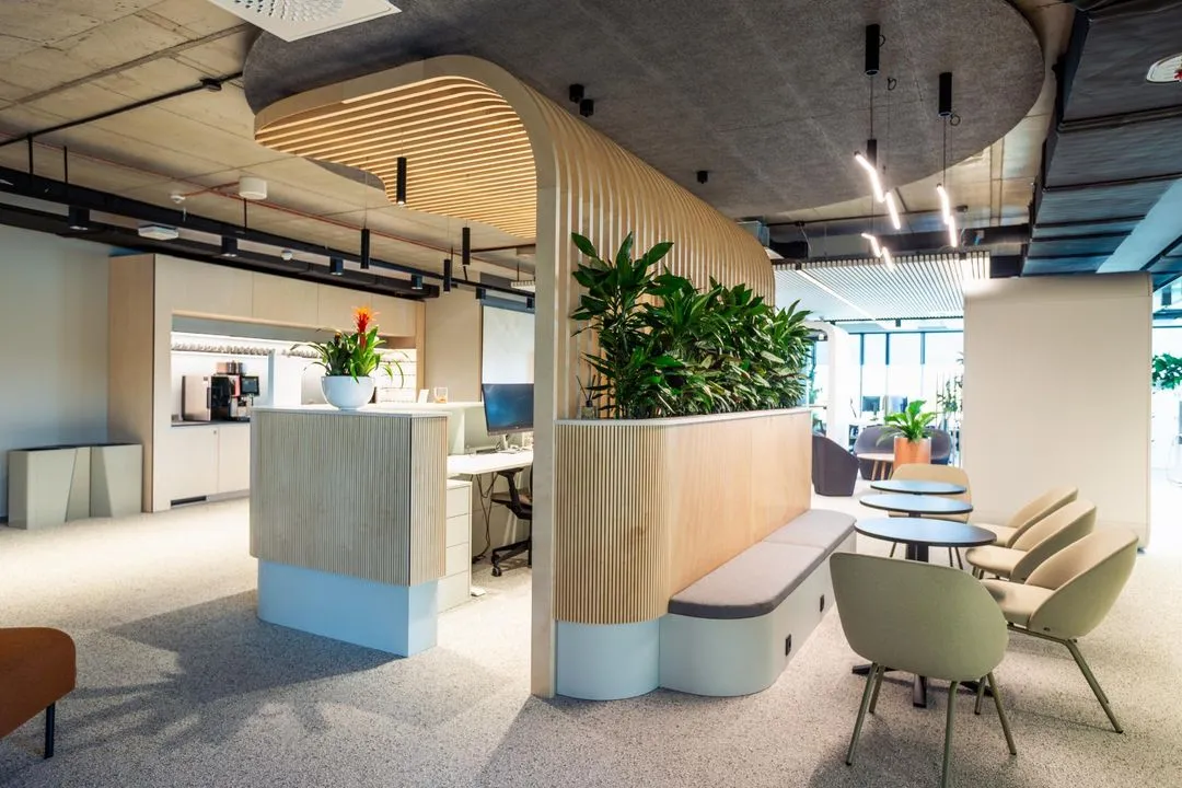 Office reception with curved wooden slat ceiling and lounge chairs