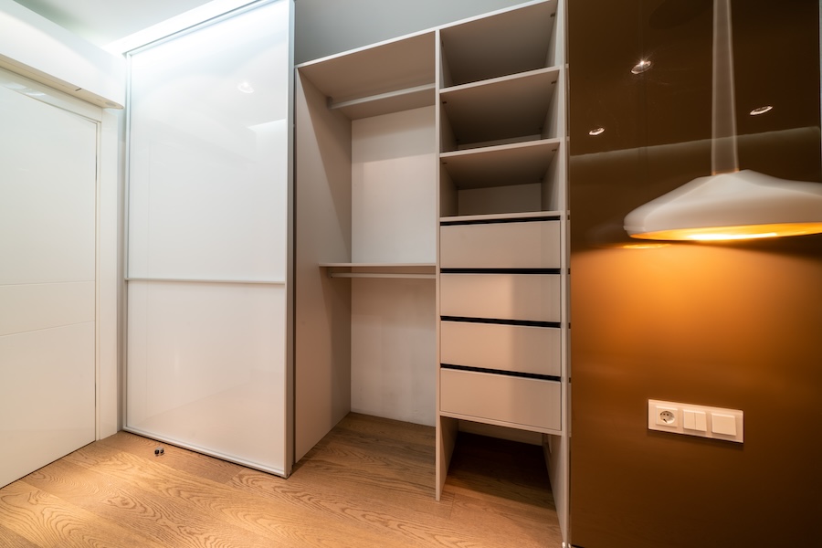 Fitted wardrobe with white sliding doors and drawers