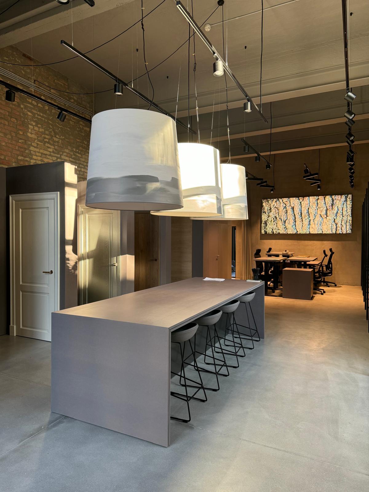 Communal table under large pendant lamps in an office