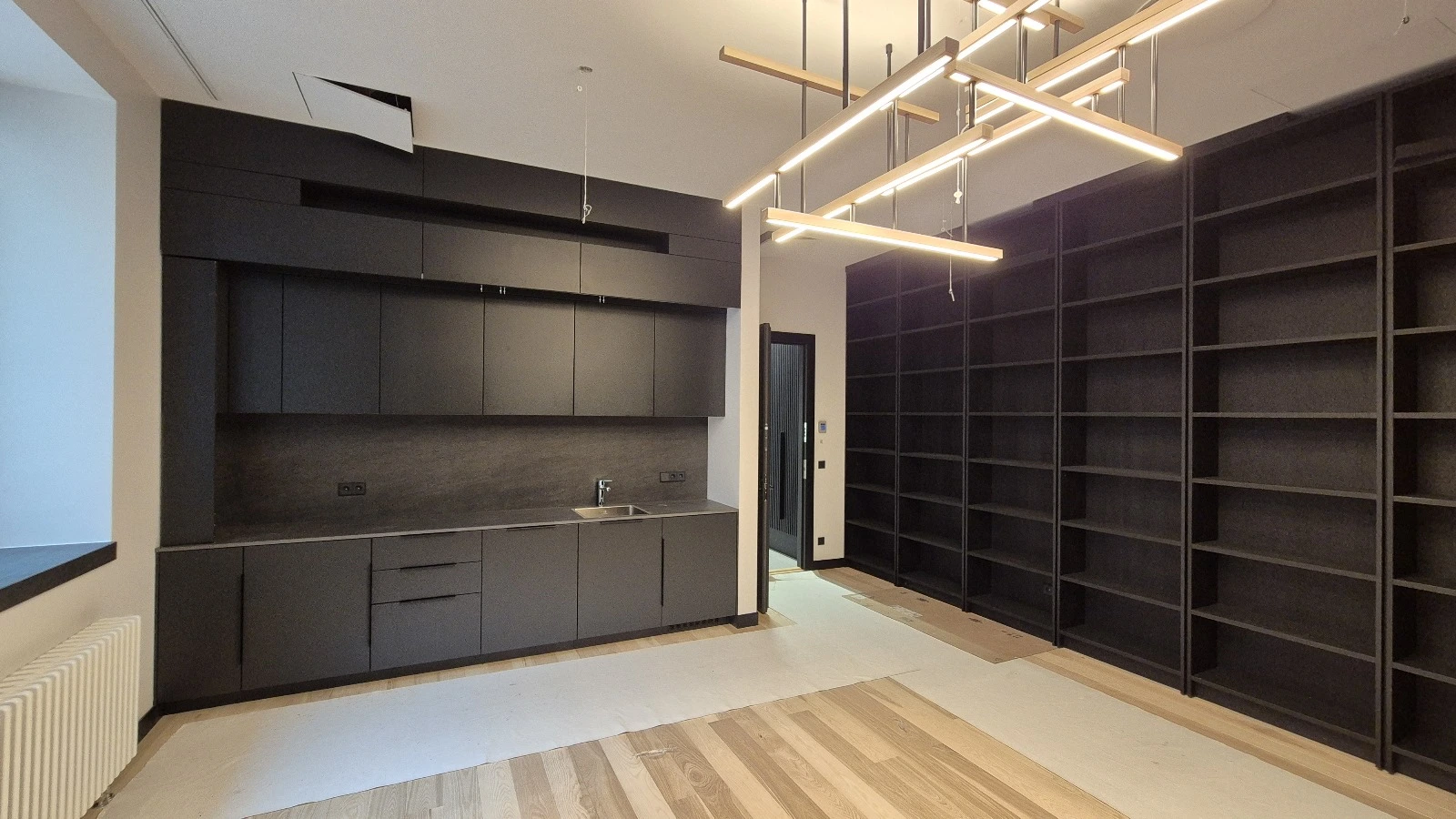 Dark built-in kitchen and floor-to-ceiling shelving