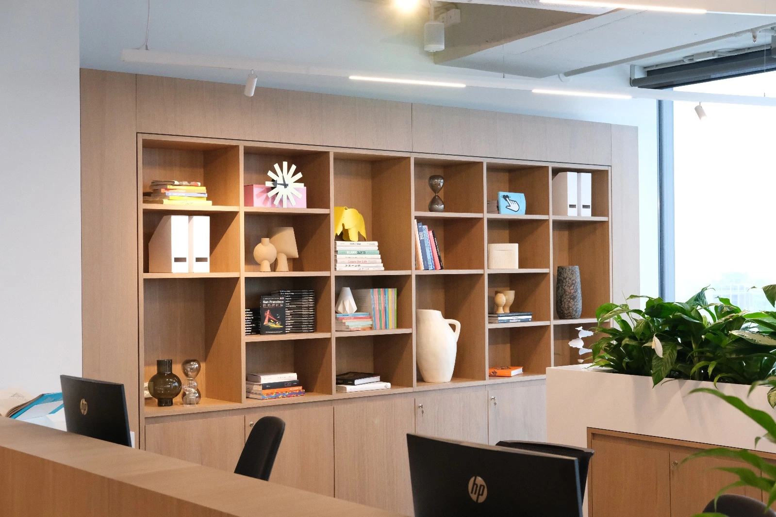 Office reception desk with oak bookshelves behind