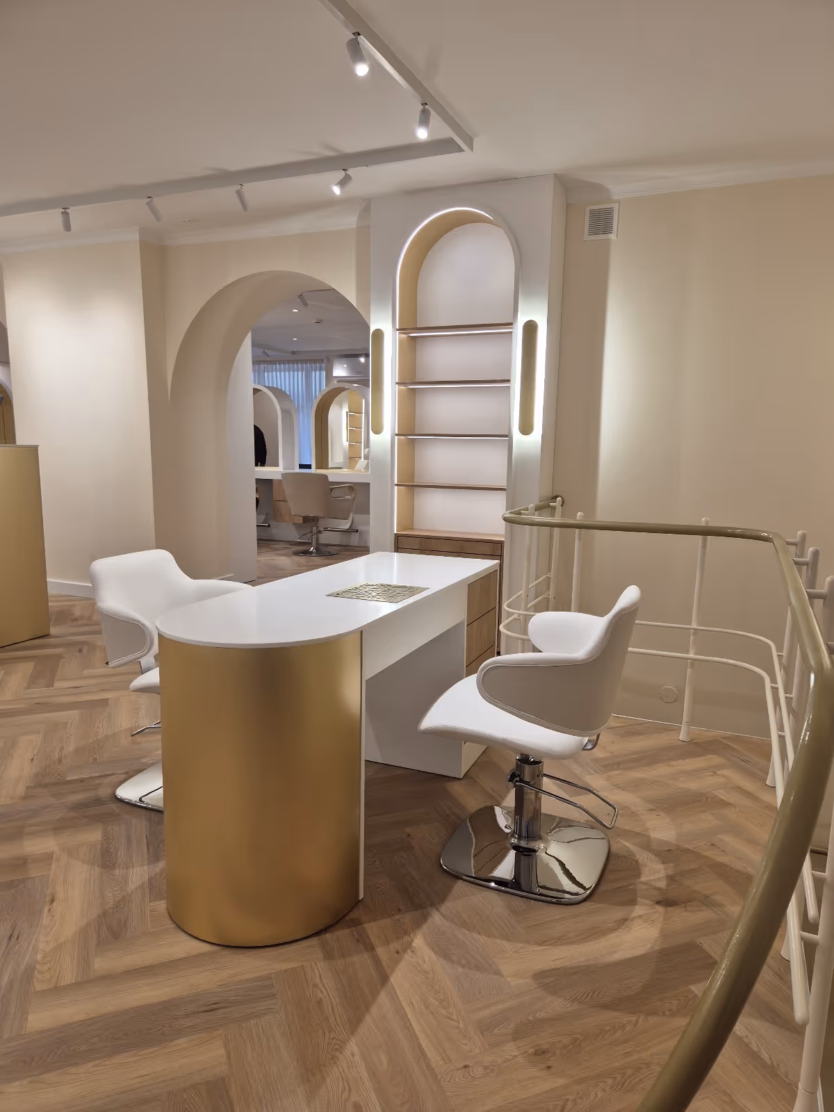 Beauty salon workstation with arched mirrors and white chairs